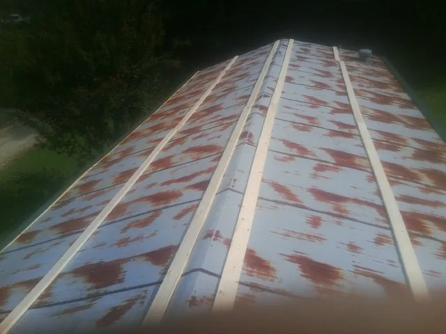 Rusted metal roof panels with new wood purlins before replacement — Storm Damage Roof Repair in Port Haywood by Roofing Brothers