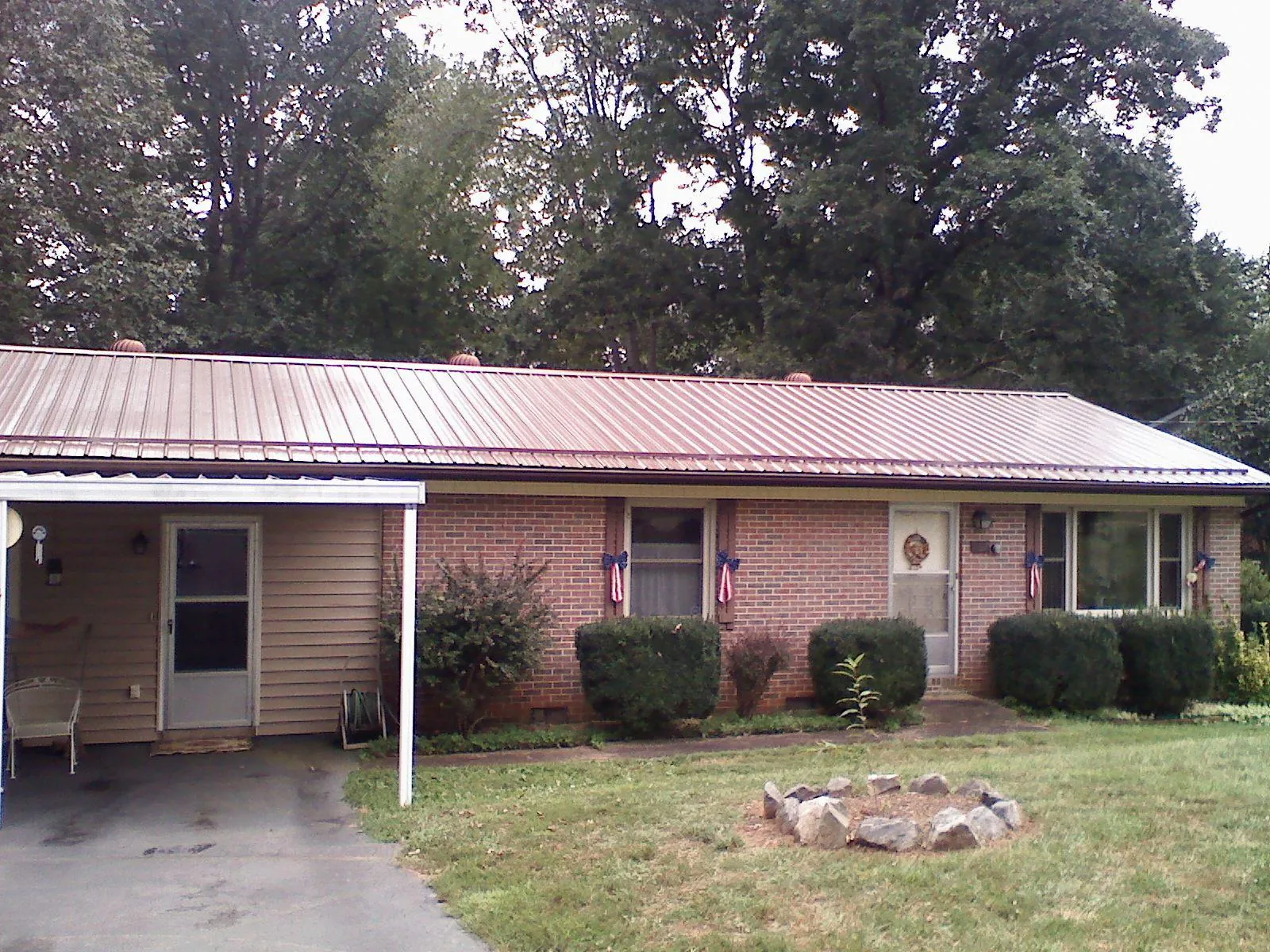 Bronze metal roof and carport on a brick ranch home — Roof Repair work by our crew in Port Haywood
