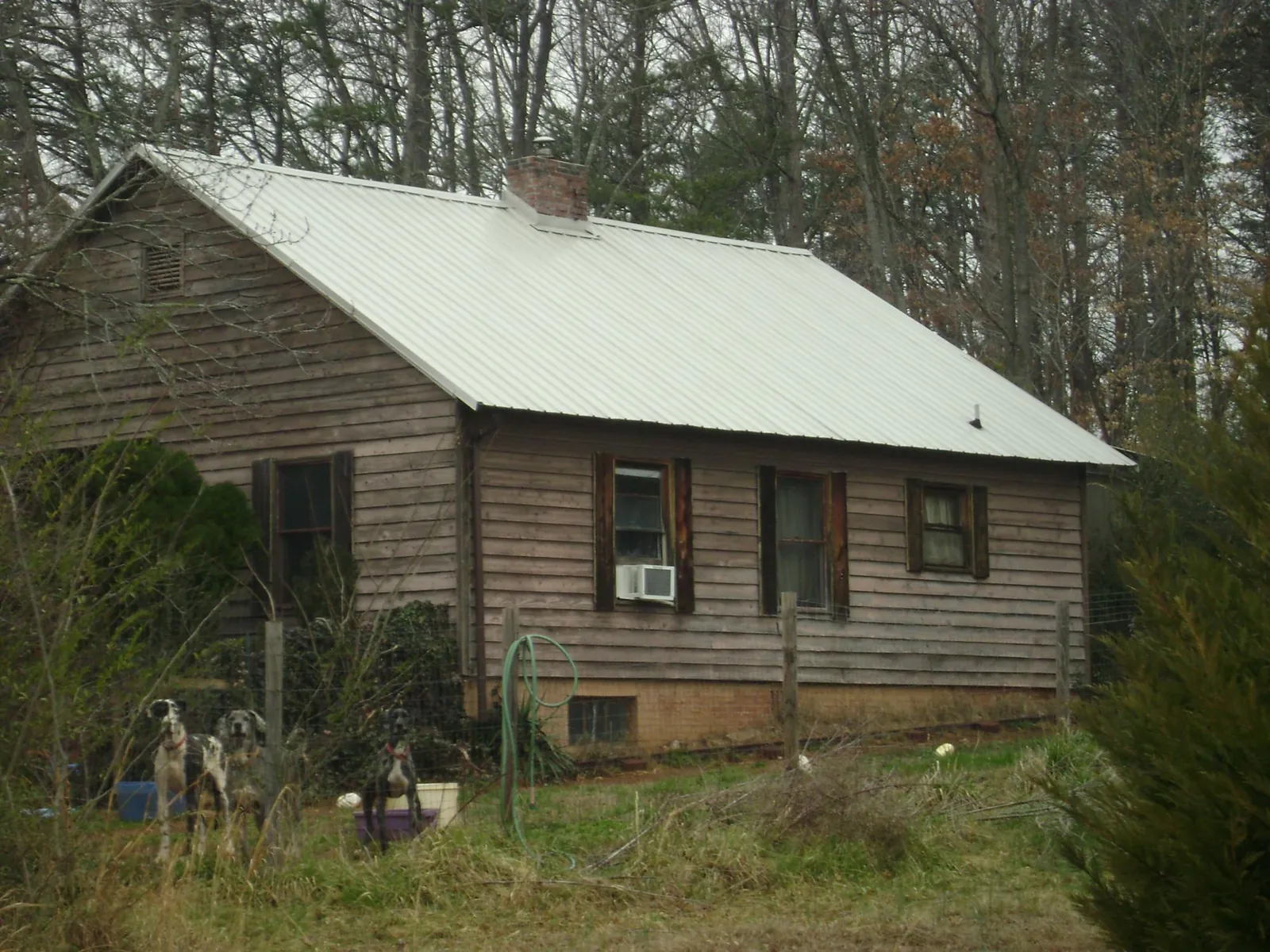 White metal roof on an old wood sided farmhouse, from a Asphalt Shingle Roof Repair job in Port Haywood